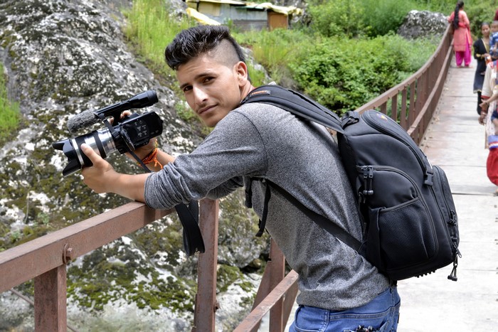 Man with camera on a bridge
