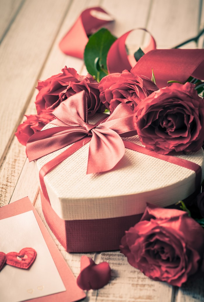Heart-shaped gift box with red roses and ribbon