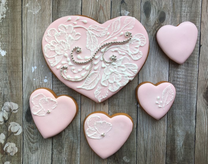 Pink heart-shaped cookies with white icing designs