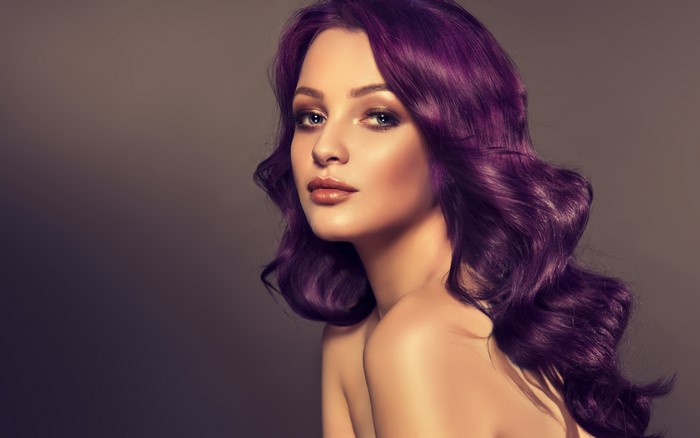Woman with purple wavy hair and makeup