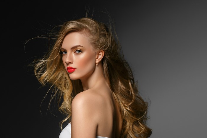 Blonde woman with red lipstick on gray background