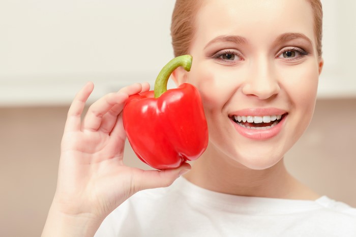 Woman holding a red bell pepper