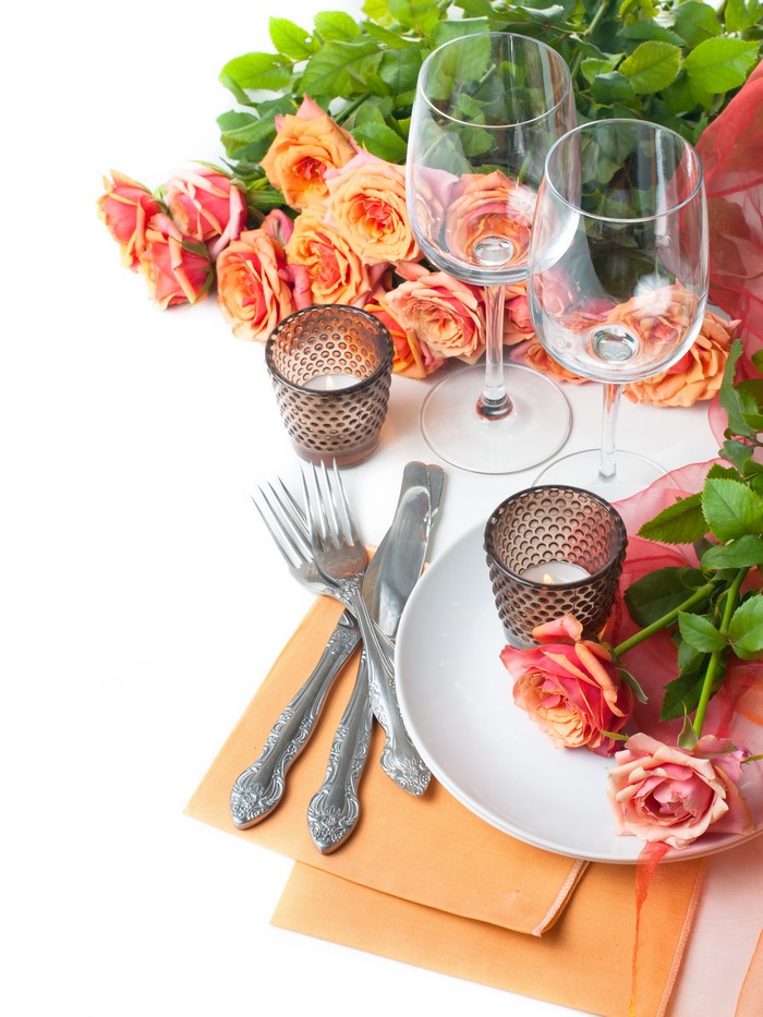 Table setting with roses, wine glasses, and candles