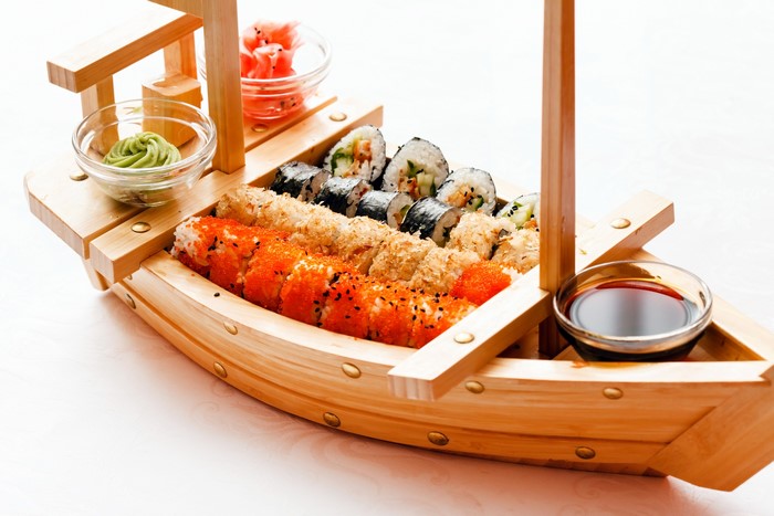 Sushi boat with wasabi, ginger, and soy sauce