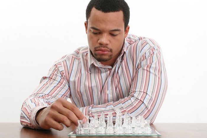 Man playing chess with glass pieces