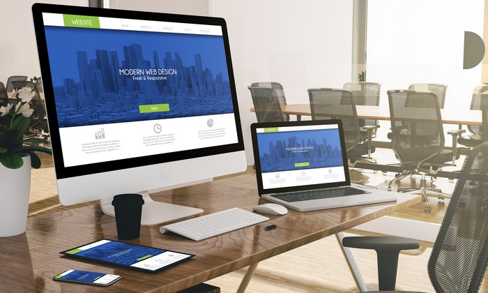 Desktop computer, laptop, tablet, and smartphone on a desk