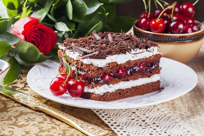 Chocolate cherry cake with whipped cream and chocolate shavings