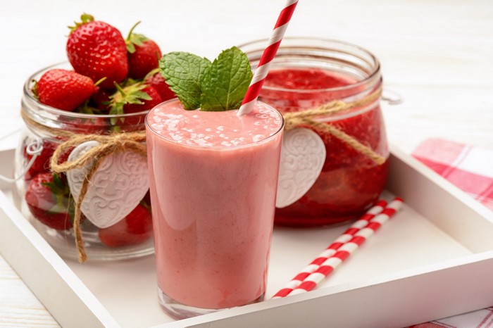 Strawberry smoothie and jam in jars with fresh strawberries