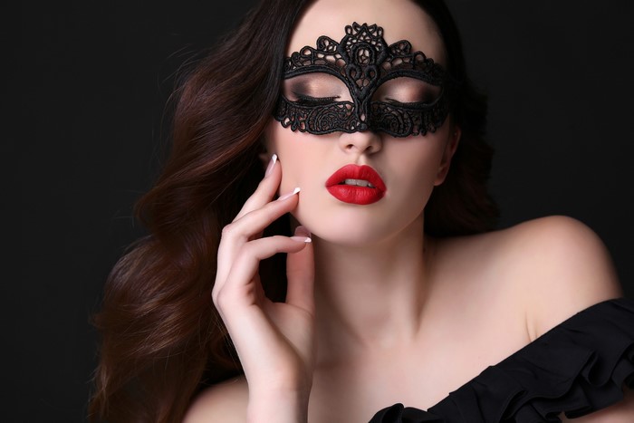 Woman with black lace mask and red lips