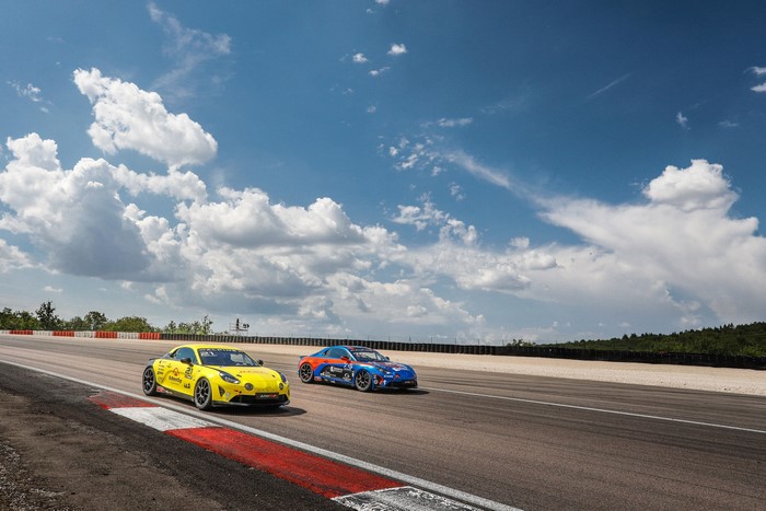 Two Alpine A110 Cup cars on a race track