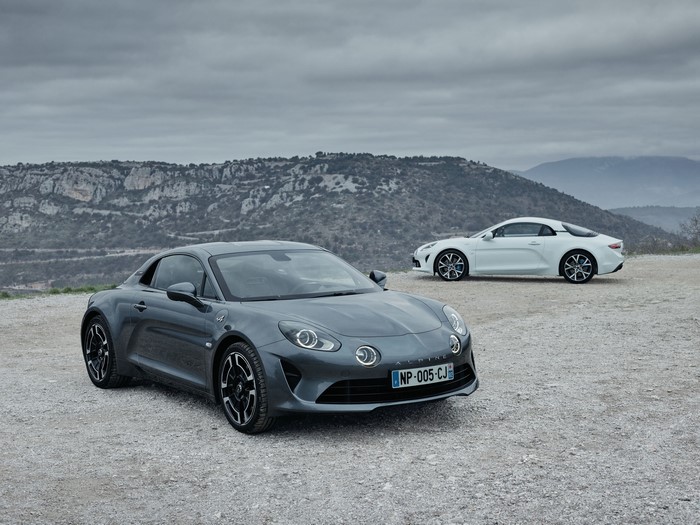 Two Alpine A110 sports cars on a rocky landscape