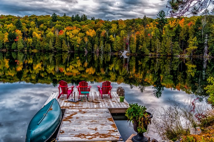 Dock with Adirondack chairs and canoe on a lake in Ontario, Canada