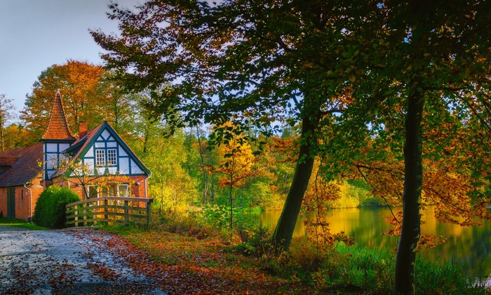 Half-timbered house by a lake in Ahausen, Germany during autumn
