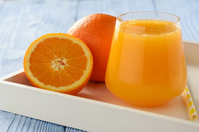 Orange juice with oranges on a tray