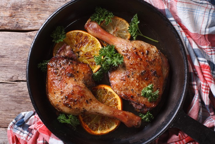 Roast Duck Legs with Orange Slices in Frying Pan
