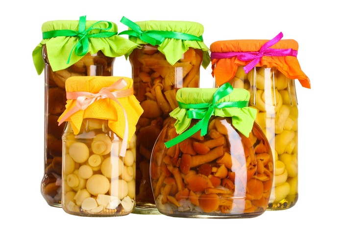 Jars of pickled mushrooms with decorative lids