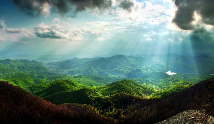 Sunbeams over green mountains and clouds