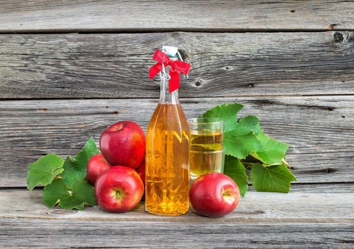 Apple juice in a bottle with apples and a glass