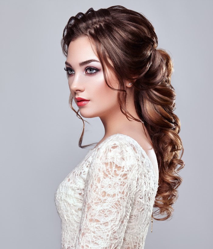 Woman with elegant brown updo and white lace dress