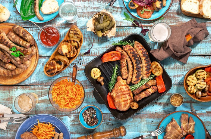 Barbecue spread with sausages, meat, grilled vegetables, and sides