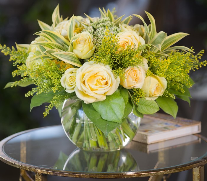 Yellow roses and greenery in a glass vase