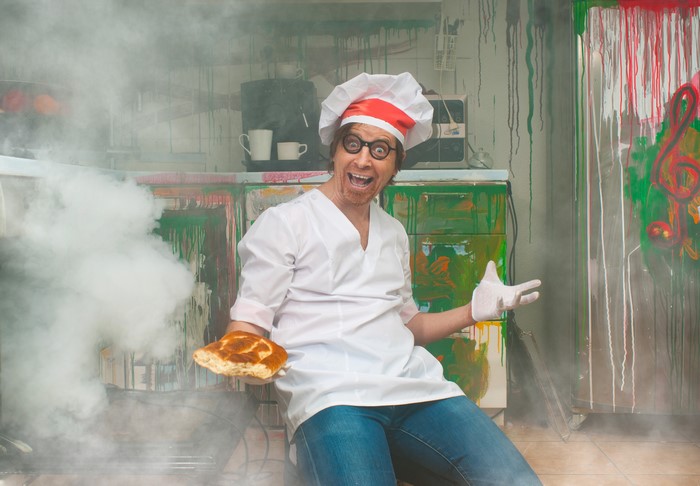Man in chef uniform with bread and smoke