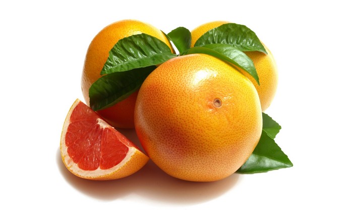 Grapefruits with leaves and slice on white background