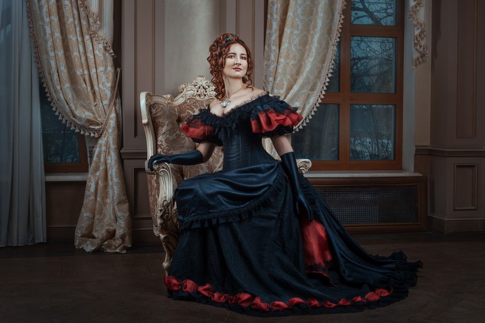 Woman in a vintage dress sitting in a chair