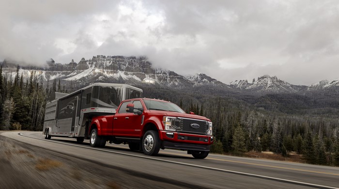 Red Ford F-450 Super Duty Limited Crew Cab towing trailer