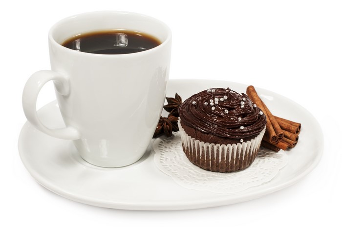 Coffee cup with chocolate cupcake and cinnamon sticks