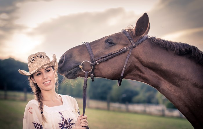 Woman in cowboy hat with horse