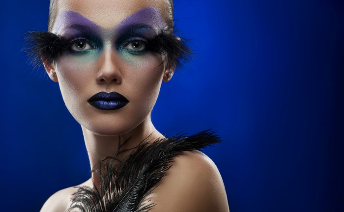 Woman with dramatic makeup and feathers