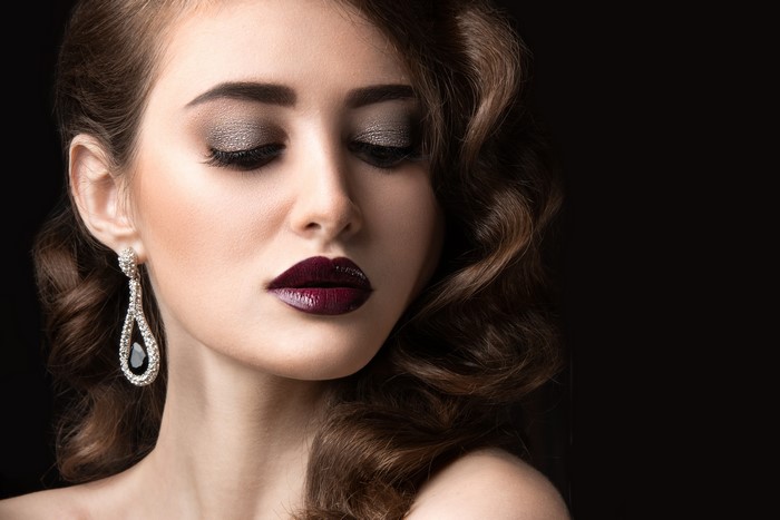Woman with dark lipstick and earrings