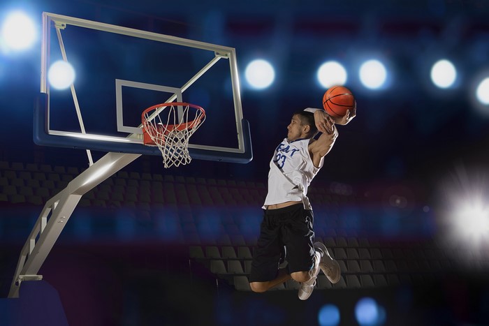 Basketball player dunking on court