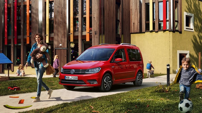 Red Volkswagen Caddy with children and woman