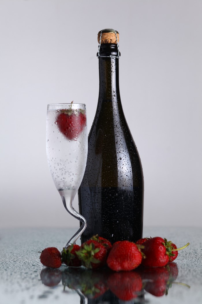 Champagne bottle with strawberries and a glass
