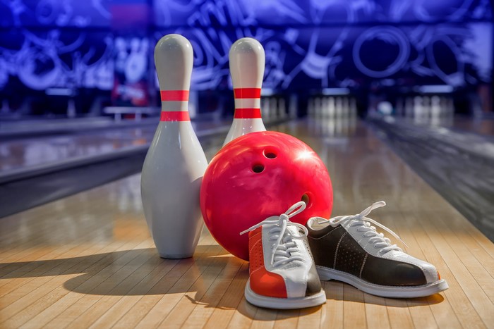Bowling pins, ball, and shoes on lane