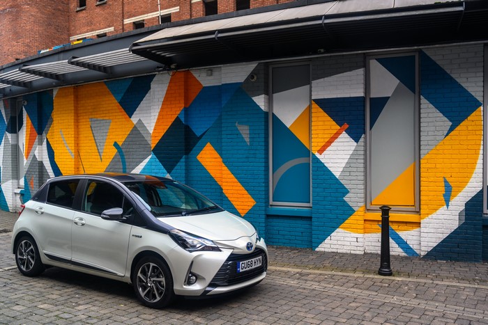 White 2019 Toyota Yaris Hybrid Y20 parked by mural