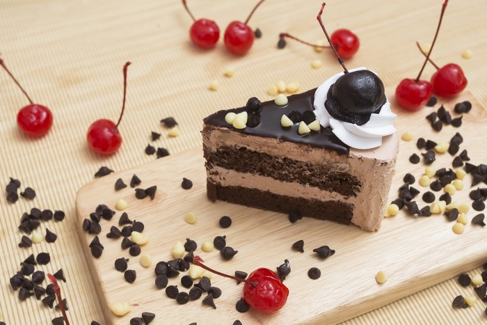 Chocolate cake slice with cherries and chocolate chips