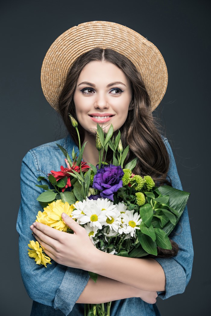 Woman in straw hat holding a bouquet of flowers