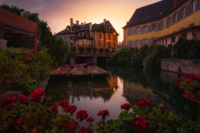 Colmar, France canal with boats and flowers at sunset