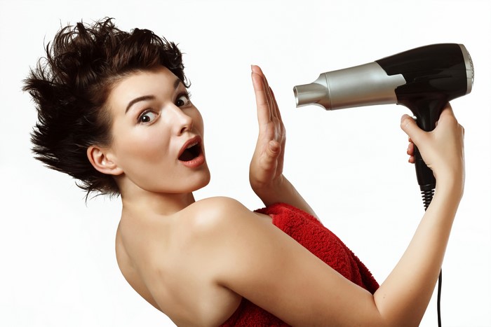 Woman with brown hair and hairdryer on white background