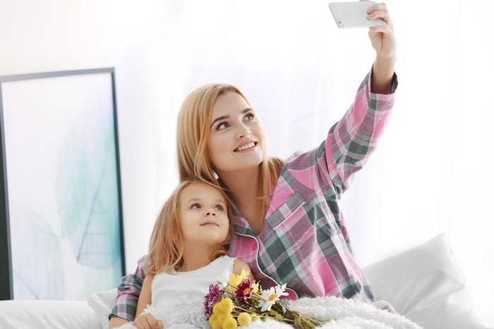 Mother and daughter taking a selfie with flowers