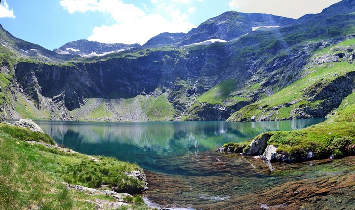Mountain lake in the Alps with green slopes