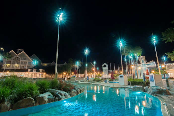 Resort pool at night with street lights and buildings