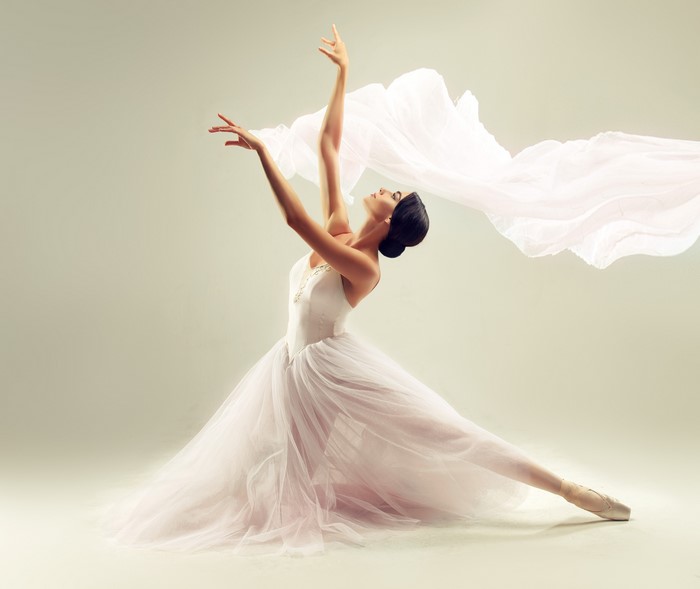 Ballerina in white tutu with flowing fabric