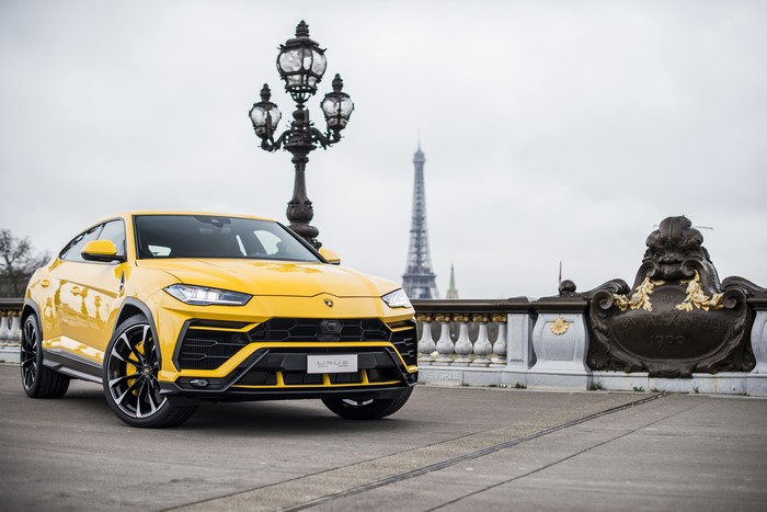 Yellow Lamborghini Urus on a bridge in Paris