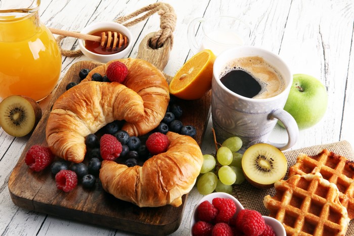 Breakfast with Croissants, Coffee, and Fruits