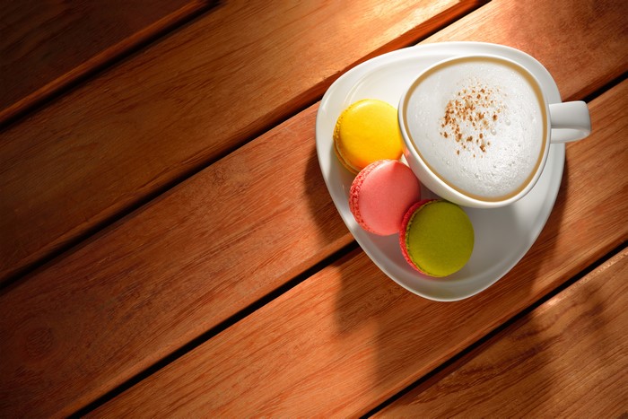 Cappuccino and macarons on wooden planks