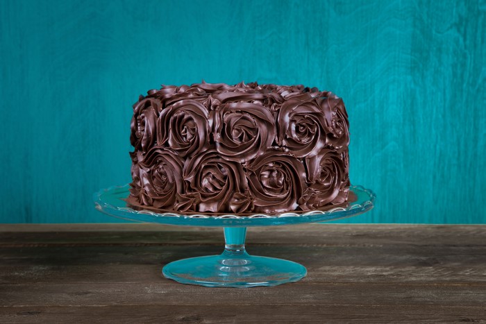 Chocolate cake with rose frosting on a cake stand